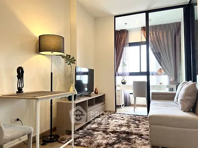 Modern living room with cozy sofa, stylish decor, and natural light from large windows.