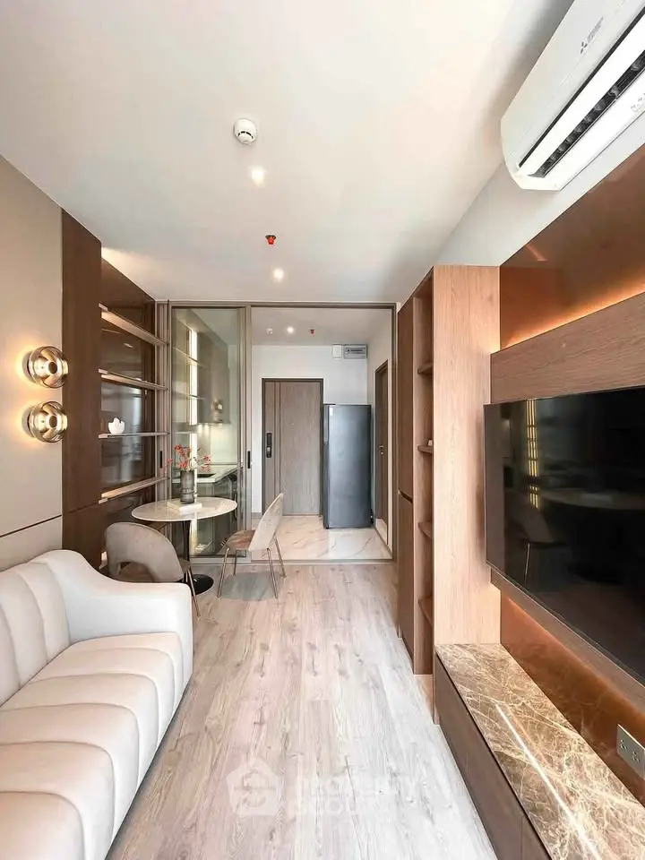 Modern living room with elegant decor and open layout, featuring a cozy sofa and sleek TV unit.