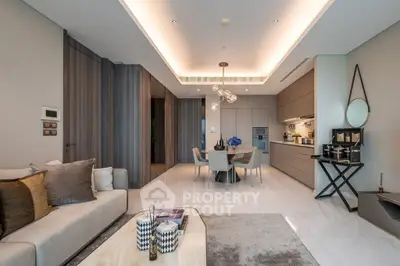 Luxurious modern living room with open kitchen, elegant decor, and ambient lighting.
