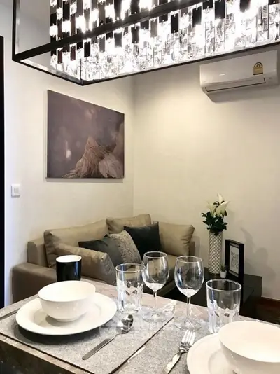 Elegant living room with modern chandelier and cozy seating area, perfect for entertaining guests.