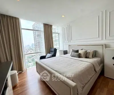 Luxurious bedroom with city view, elegant decor, and ample natural light in modern apartment.