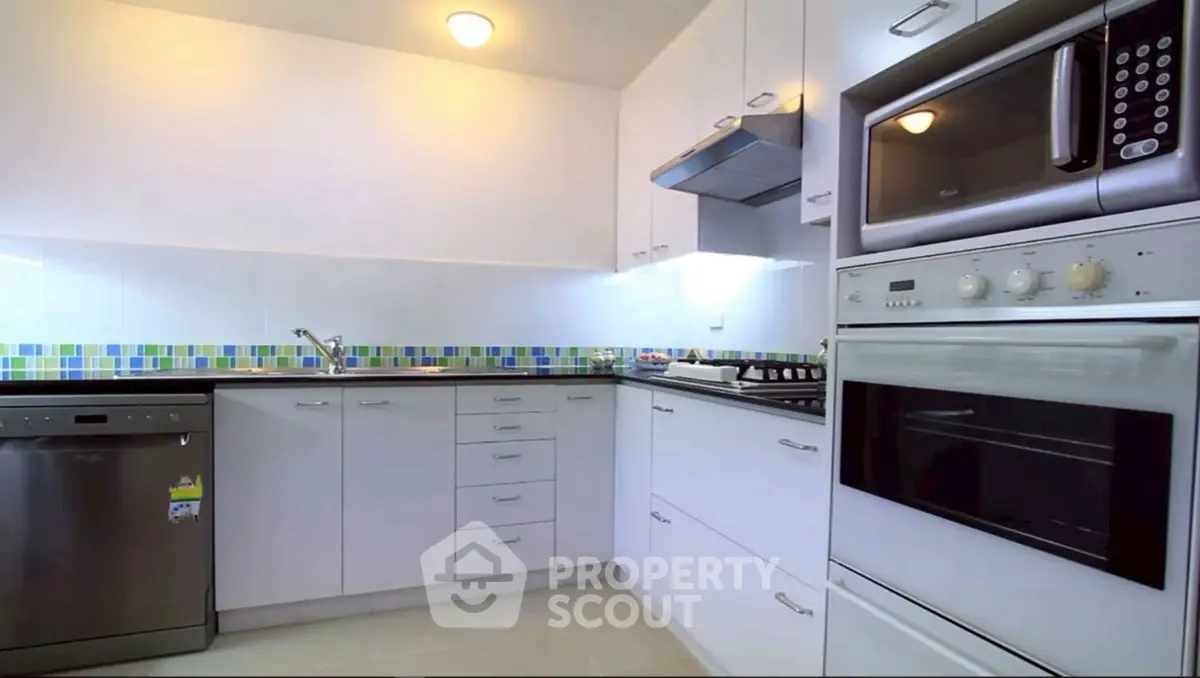 Modern kitchen with sleek appliances and colorful backsplash