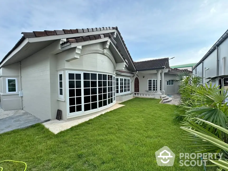 Charming single-story home with lush green lawn and elegant windows