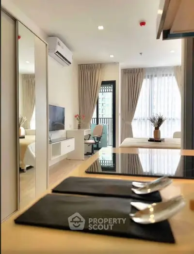 Modern studio apartment with open layout, featuring sleek kitchen and cozy living area with natural light.