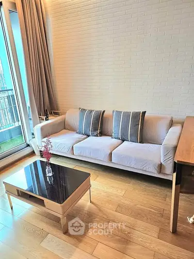 Modern living room with stylish sofa and elegant coffee table near balcony.