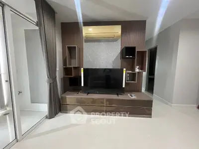 Modern living room with sleek TV unit and air conditioning, featuring elegant design and ample storage.