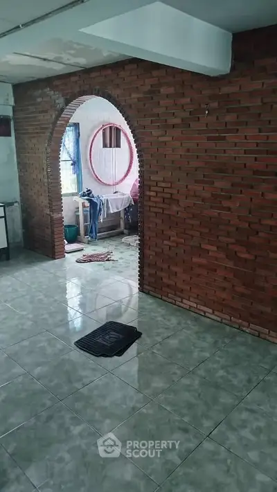 Charming rustic interior with exposed brick archway and tiled flooring