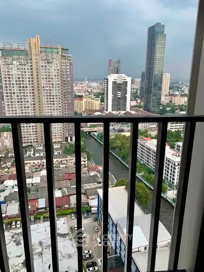 Stunning cityscape view from high-rise balcony overlooking urban skyline and river.