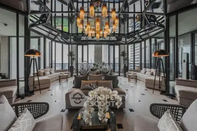 Luxurious living room with modern design, featuring large windows and elegant chandelier.