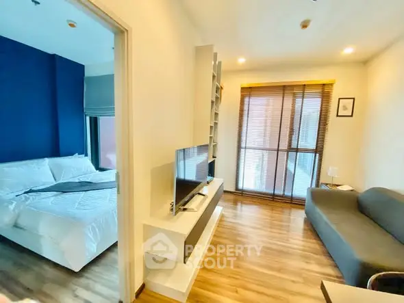 Modern apartment with cozy living room and stylish bedroom, featuring wooden flooring and natural light.