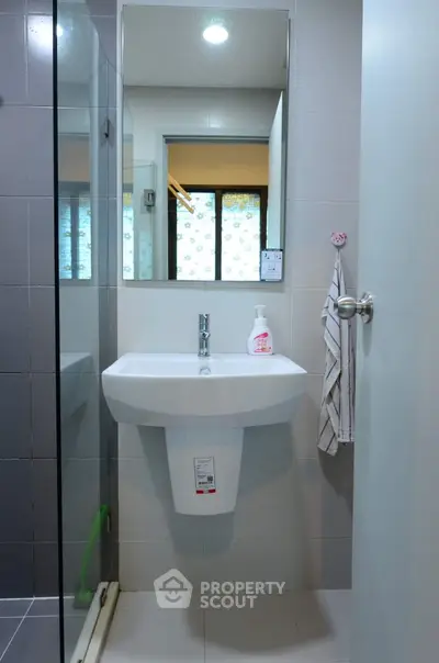 Modern bathroom with sleek sink and mirror in contemporary apartment.