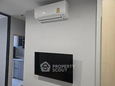 Modern interior with wall-mounted TV and air conditioning unit in a sleek apartment.