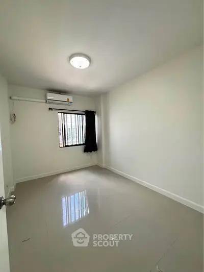 Spacious empty room with air conditioning and natural light, perfect for customization.
