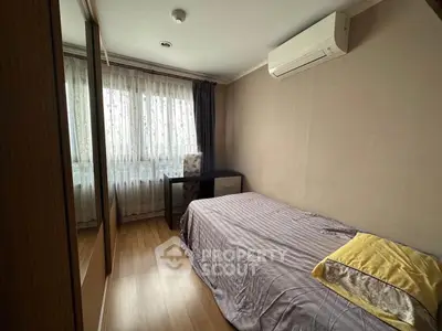 Cozy bedroom with single bed, large window, and air conditioning unit.