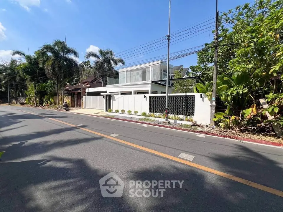 Modern luxury home with sleek design and lush greenery in a serene neighborhood.