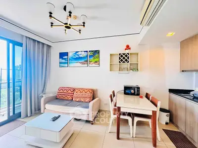 Modern living room with stylish decor, large windows, and open kitchen layout in a high-rise apartment.