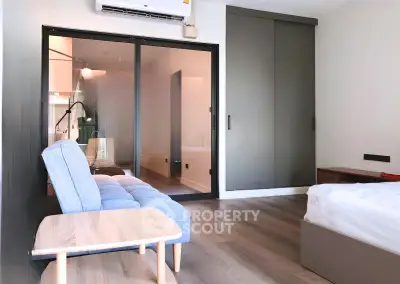 Modern bedroom with sliding glass doors and cozy seating area
