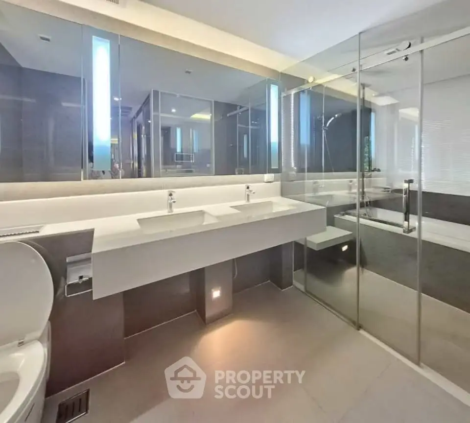 Luxurious modern bathroom with dual sinks and glass shower enclosure