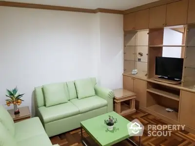 Cozy living room with green sofa and wooden entertainment unit