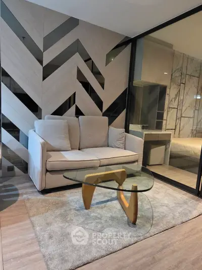 Modern living room with stylish sofa and glass coffee table in luxury apartment.