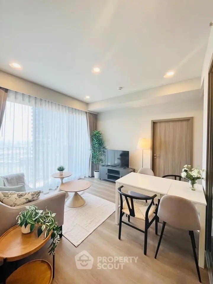 Modern living room with elegant decor and large windows offering natural light.