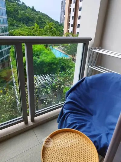 Charming balcony with lush green view and cozy seating, perfect for relaxation.
