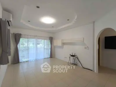 Spacious living room with modern ceiling design and large windows for natural light.