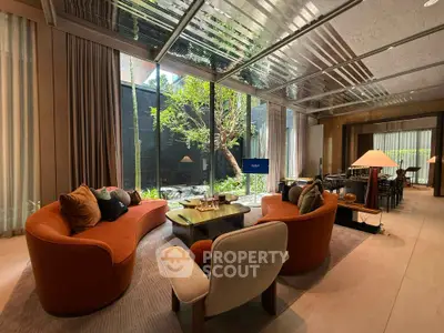 Luxurious living room with modern furniture and large windows overlooking a serene garden.