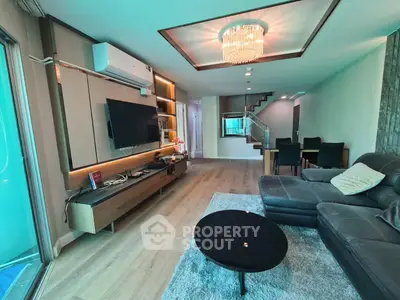 Modern living room with stylish decor, leather sofa, and elegant lighting in a spacious open layout.