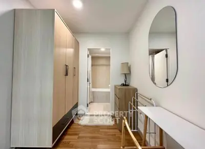 Modern bedroom with wooden flooring, wardrobe, and stylish mirror