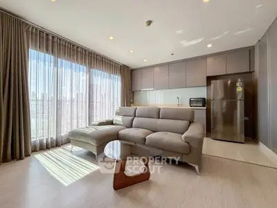 Modern living room with large windows and sleek furniture in a high-rise apartment.