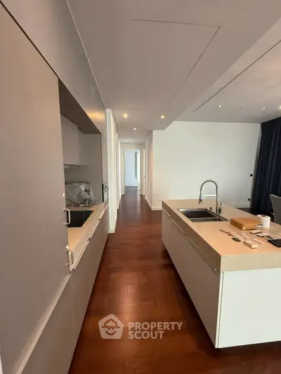 Modern kitchen with sleek cabinetry and island in open layout apartment