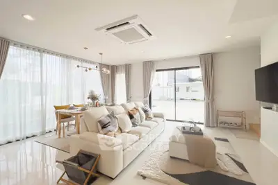 Spacious modern living room with elegant decor and large windows offering natural light.