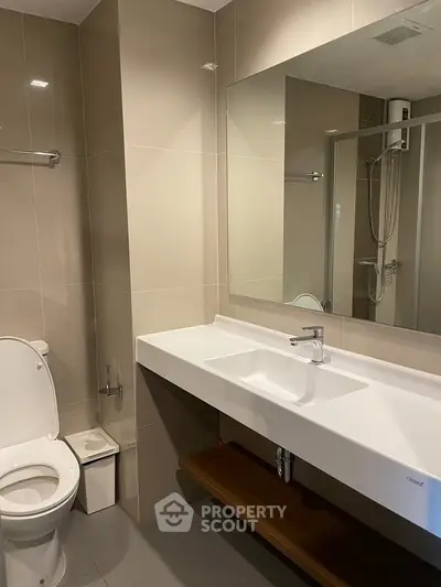 Modern bathroom with sleek fixtures and spacious shower area, perfect for contemporary living.