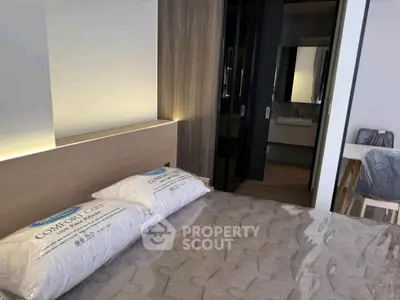 Modern bedroom with stylish decor and ensuite bathroom in a contemporary apartment.