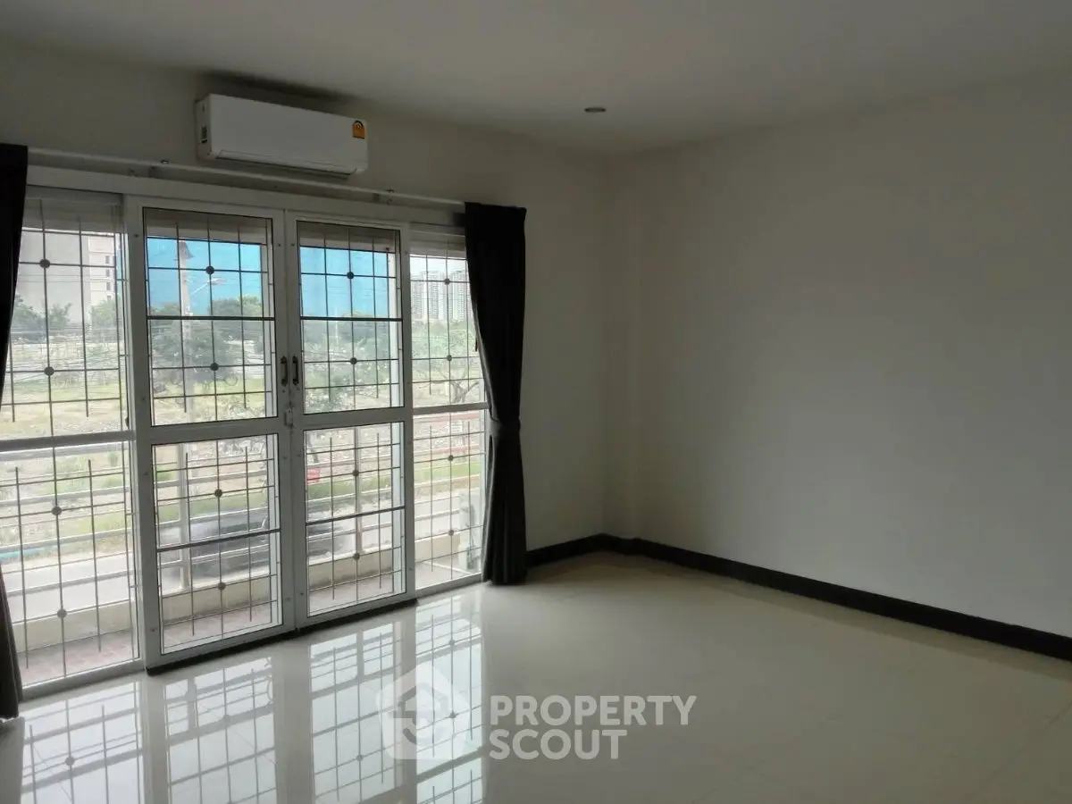 Spacious empty room with large windows and air conditioning, ideal for customization.