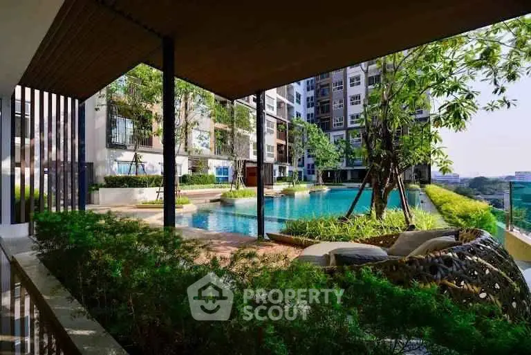 Luxurious condominium pool area with lush greenery and modern design, offering a serene urban oasis.