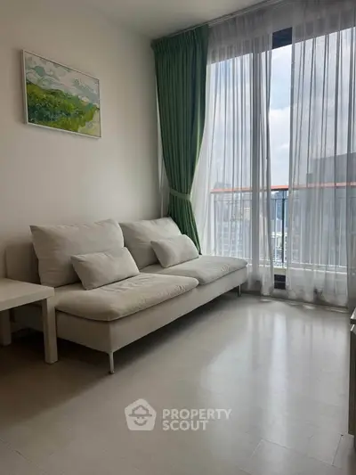 Bright living room with large window and modern sofa, offering a cozy and inviting atmosphere.