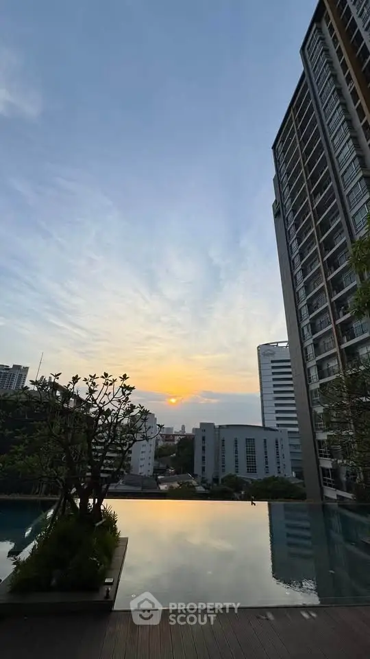 Stunning sunset view from a modern high-rise building with infinity pool.