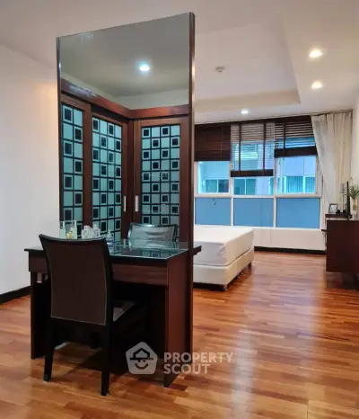 Spacious bedroom with elegant wooden flooring and modern decor