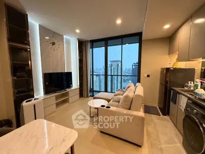 Modern living room with city view, featuring cozy seating and sleek kitchen appliances.
