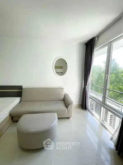 Bright modern living room with large windows and stylish furniture, perfect for relaxation.