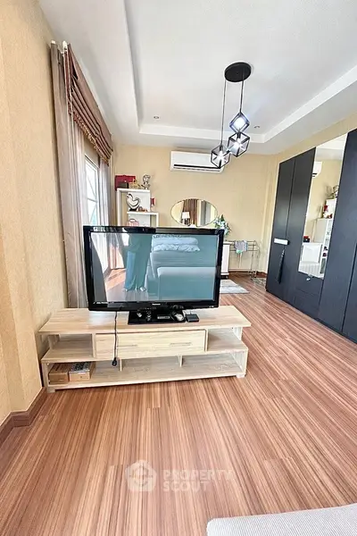 Stylish bedroom with modern TV setup and elegant wooden flooring