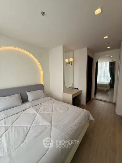 Modern bedroom with stylish lighting and cozy decor in a contemporary apartment.