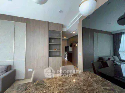 Modern open-plan living and dining area with stylish kitchen and marble table.