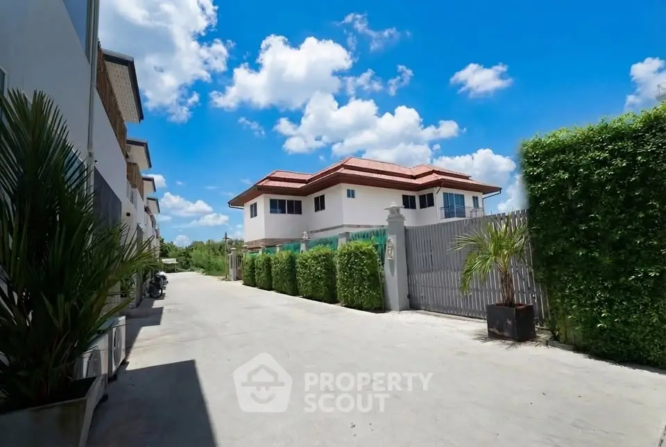 Stunning modern house with lush greenery and clear blue sky, perfect for serene living.