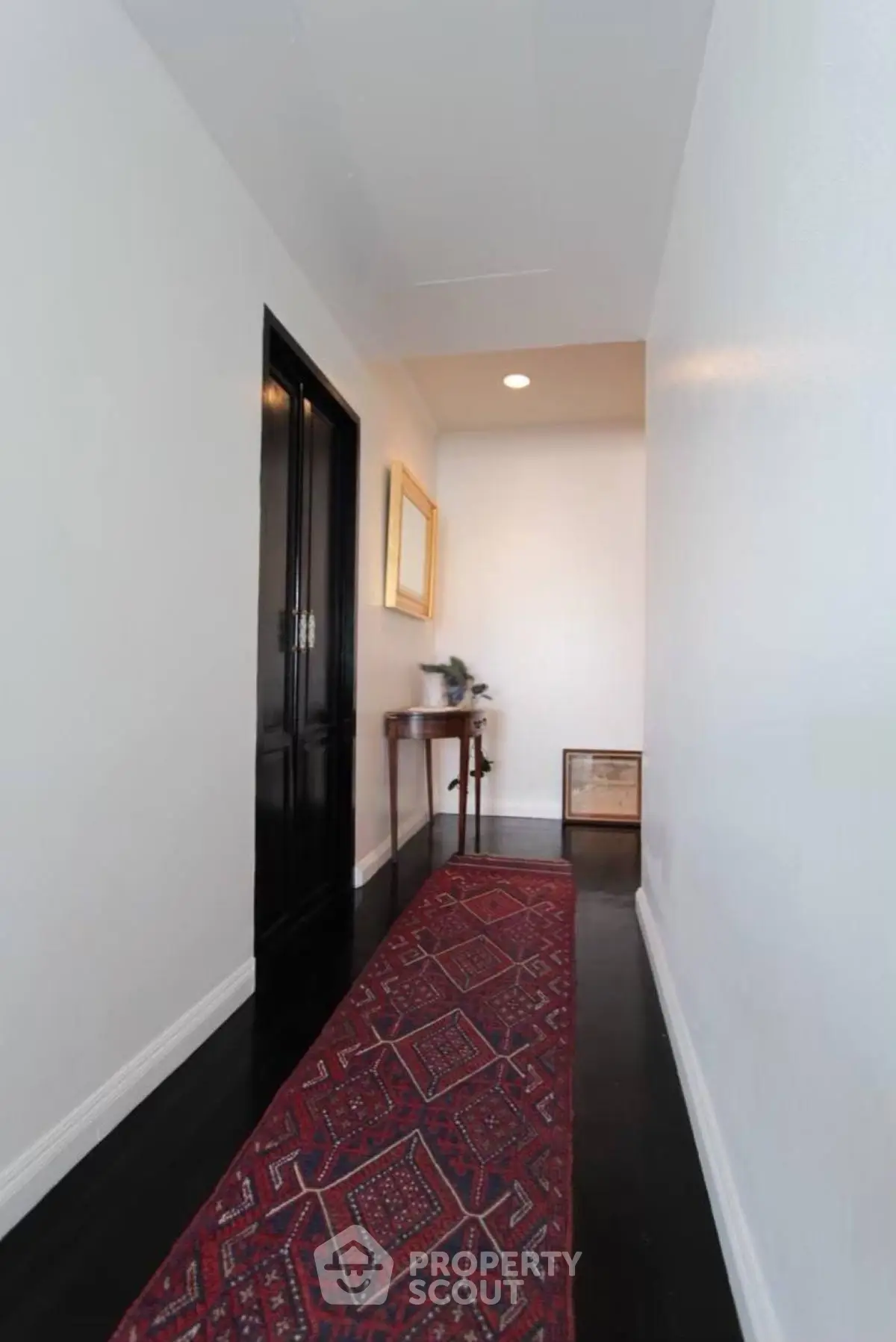 Elegant hallway with dark wood flooring and decorative rug