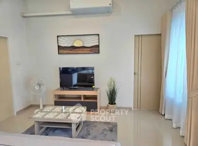 Modern living room with stylish decor and air conditioning, featuring a TV and elegant curtains.