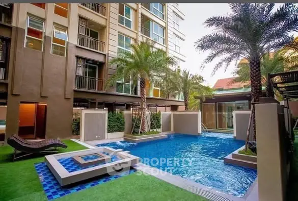Luxurious apartment complex with pool and palm trees, perfect for relaxation.