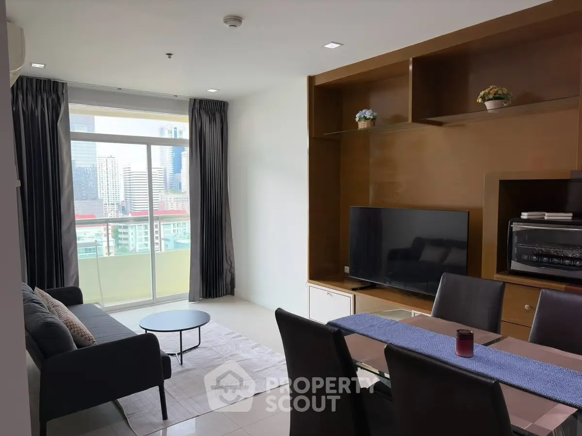 Modern living room with city view, featuring sleek furniture and large windows for natural light.